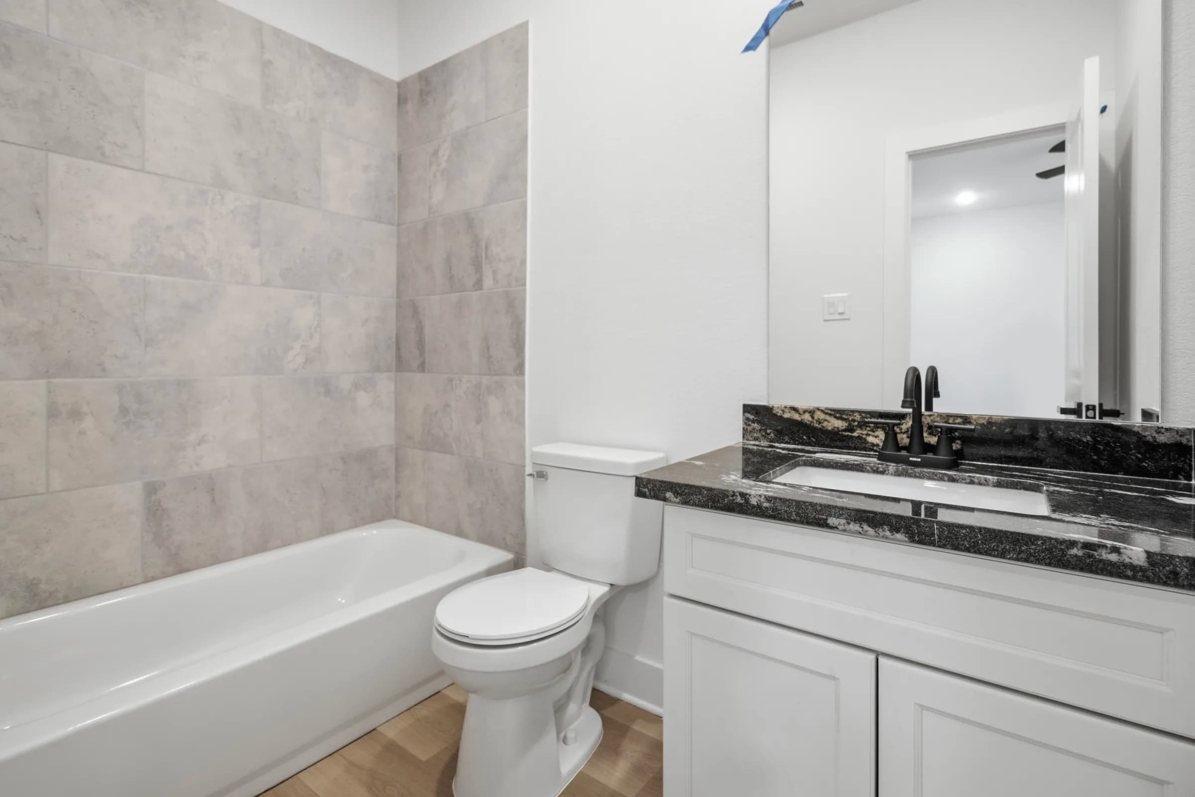 Bathroom with tiled tub surround and granite vanity